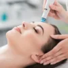 Atsipalaidavusios moters su užmerktomis akimis stambus planas per HydraFacial procedūrą ramiame salone