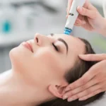 Atsipalaidavusios moters su užmerktomis akimis stambus planas per HydraFacial procedūrą ramiame salone