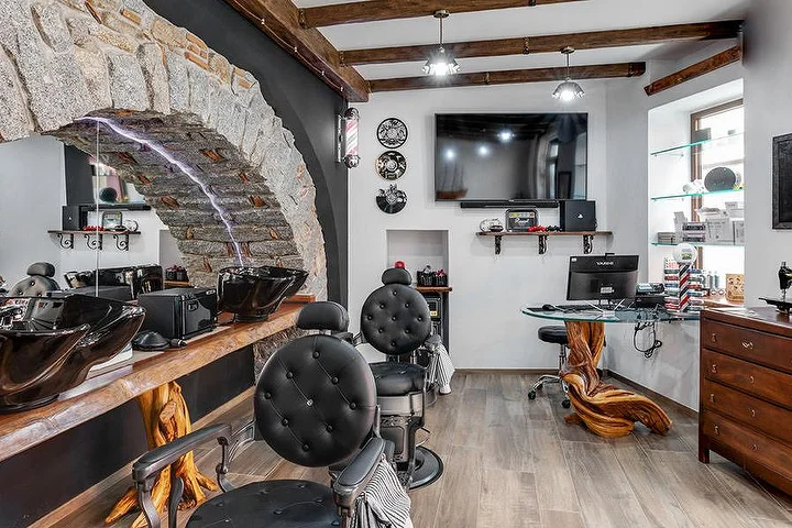 Rustikali barzdaskučio kėdė prie akmens arkos sienos La Bottega di Pablo salone, kalnų miestelyje Lanusei.