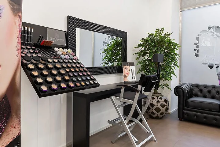 Šviesus manikiūro salonas Top Estetica Villanova rajone, Cagliari, su turkio spalvos siena, gėlėtais staliukais ir marmurinėmis grindimis.